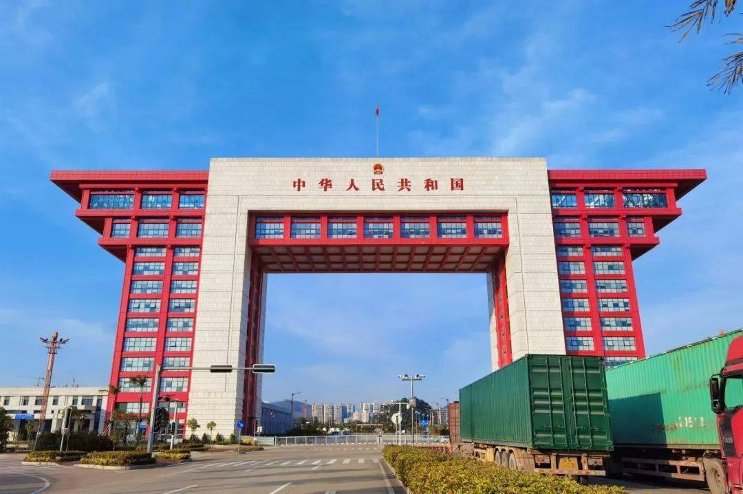 东兴二桥口岸国门楼实景，门前有集装箱货车